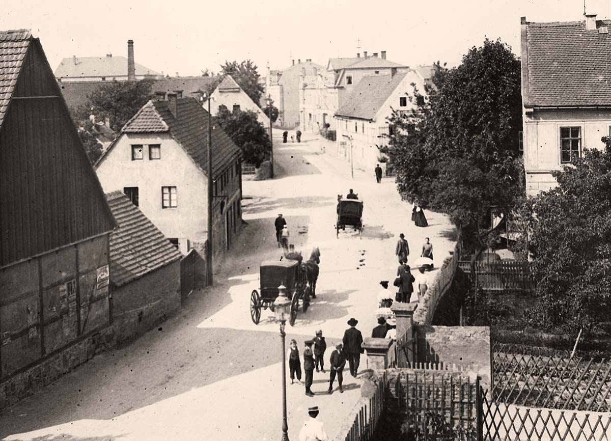 Coswig (Sachsen). Hauptstraße mit Pferdekutschen, rechts - die alte Schule von 1865, um 1900