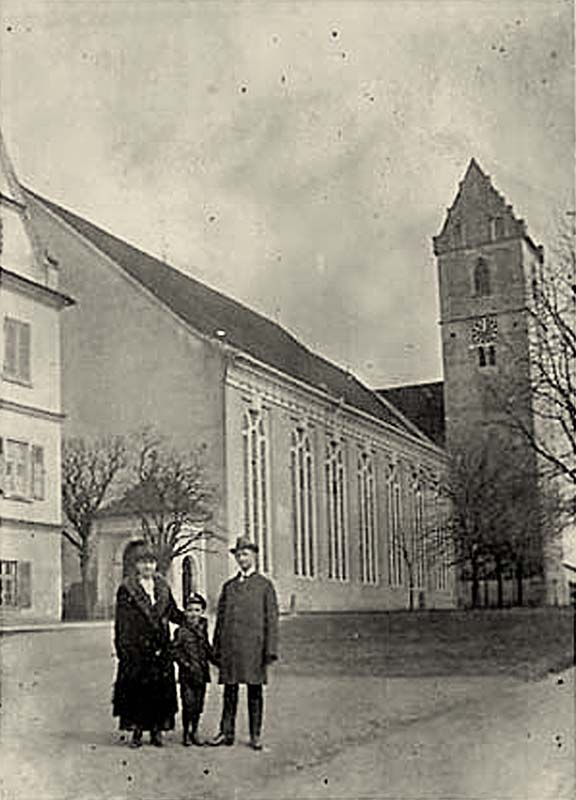 Bad Buchau. Familie mit Kind vor der Kirche