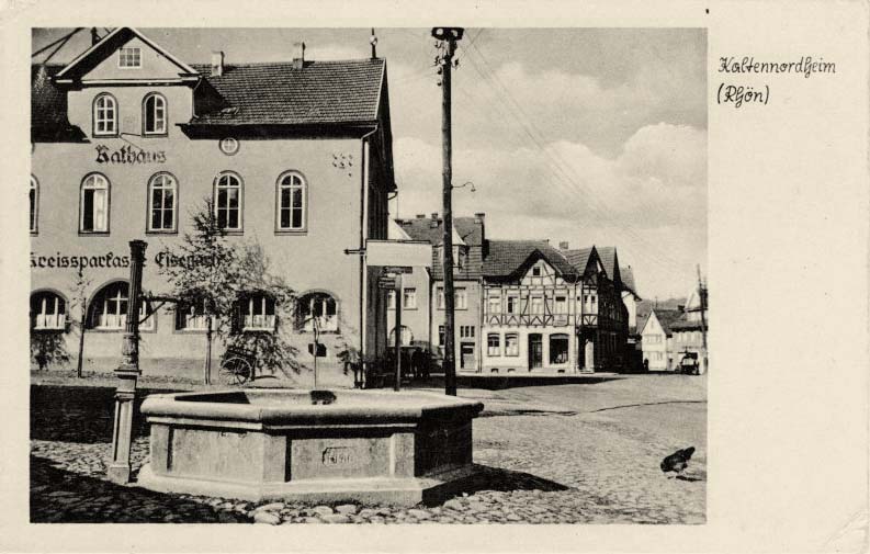 Kaltennordheim. Rathaus, Sparkasse und brunnen, 1953