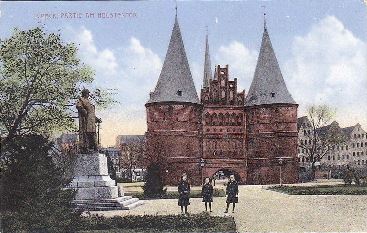 Lübeck. Holstentor und drei mädchen neben Denkmal